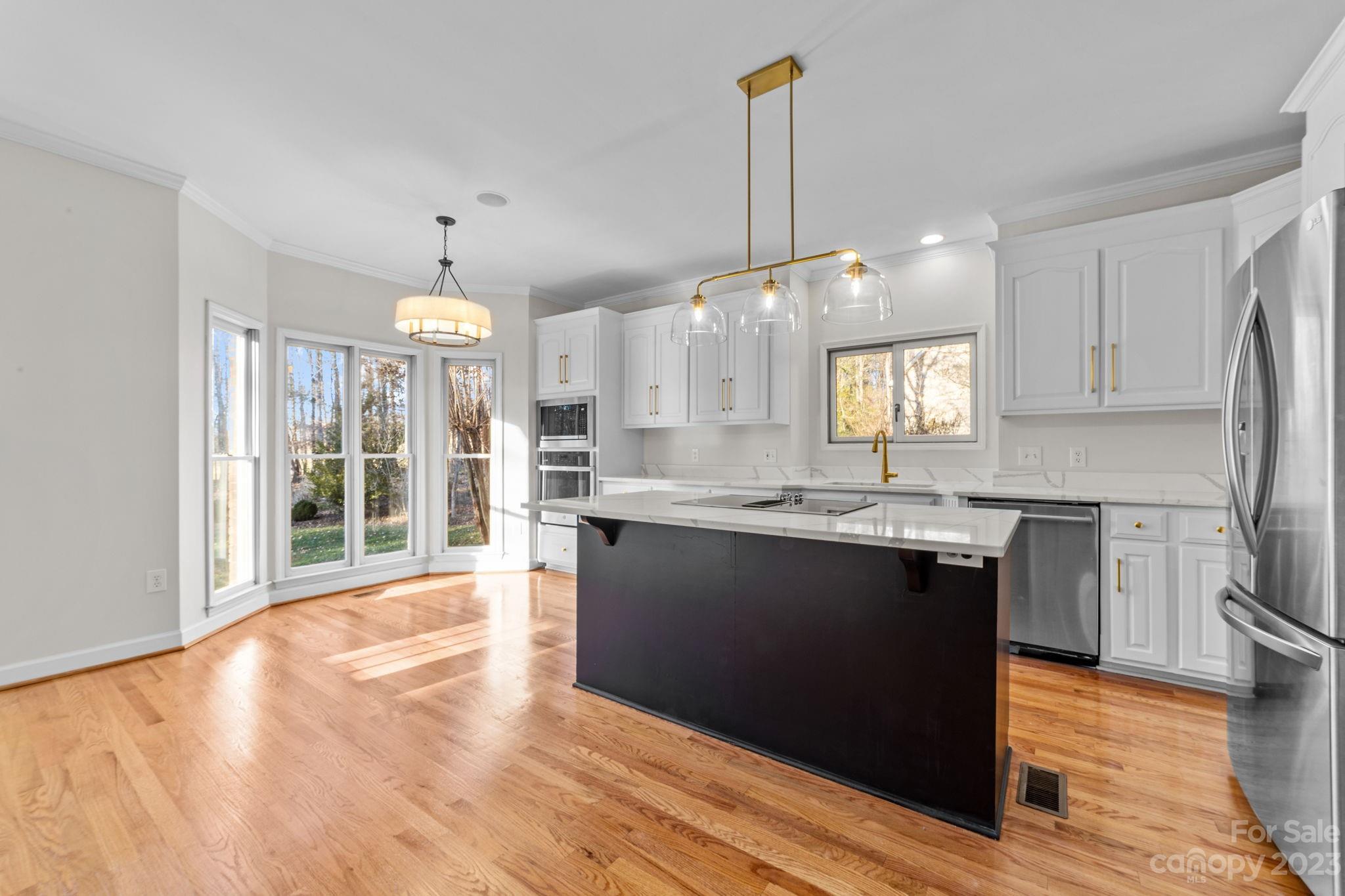 5476 Deer Run Court Davidson, NC 28036 - Photo 19 of 48 a kitchen with stainless steel appliances granite countertop a sink a stove and a wooden floors