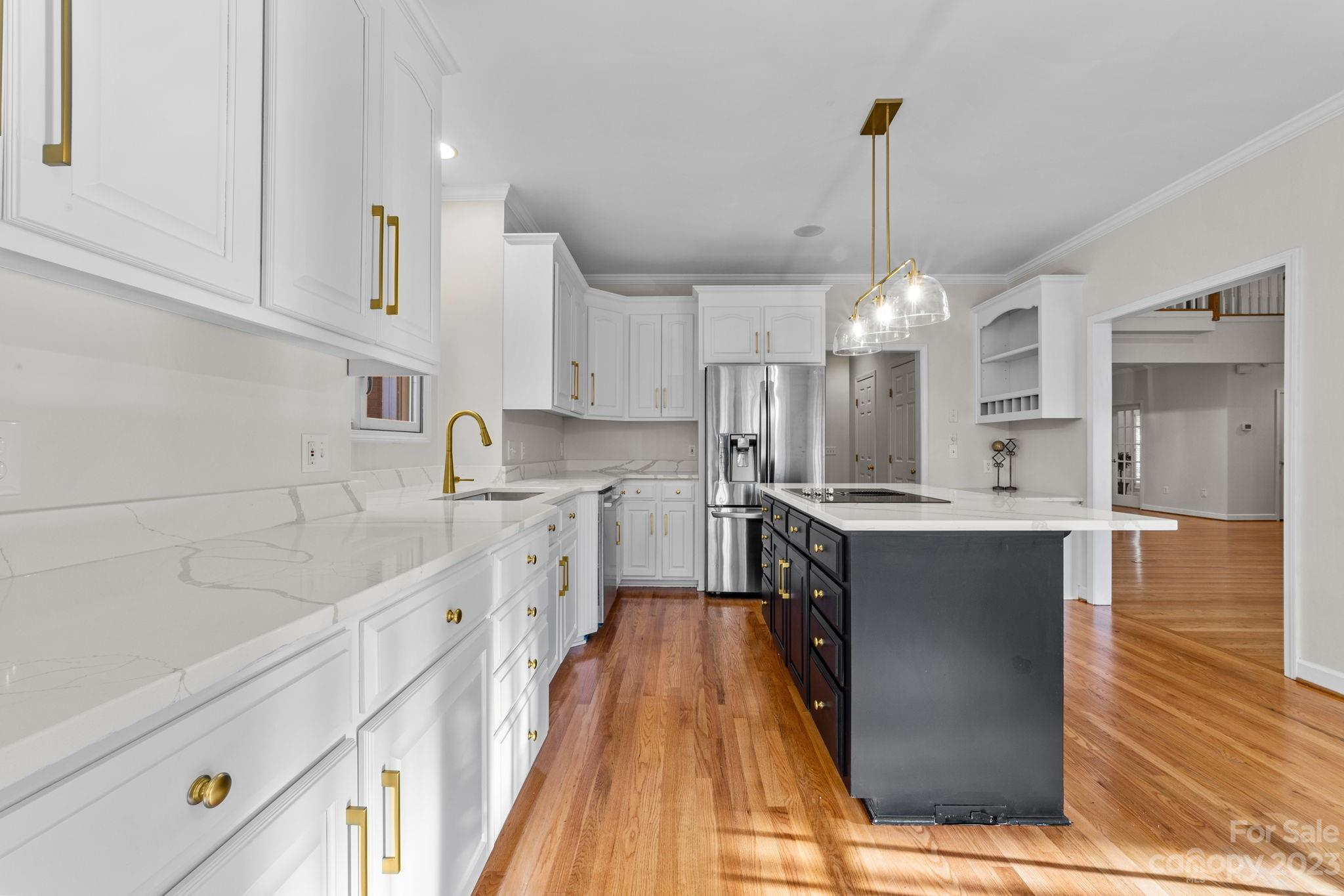 5476 Deer Run Court Davidson, NC 28036 - Photo 21 of 48 a kitchen with kitchen island granite countertop a sink cabinets and wooden floor