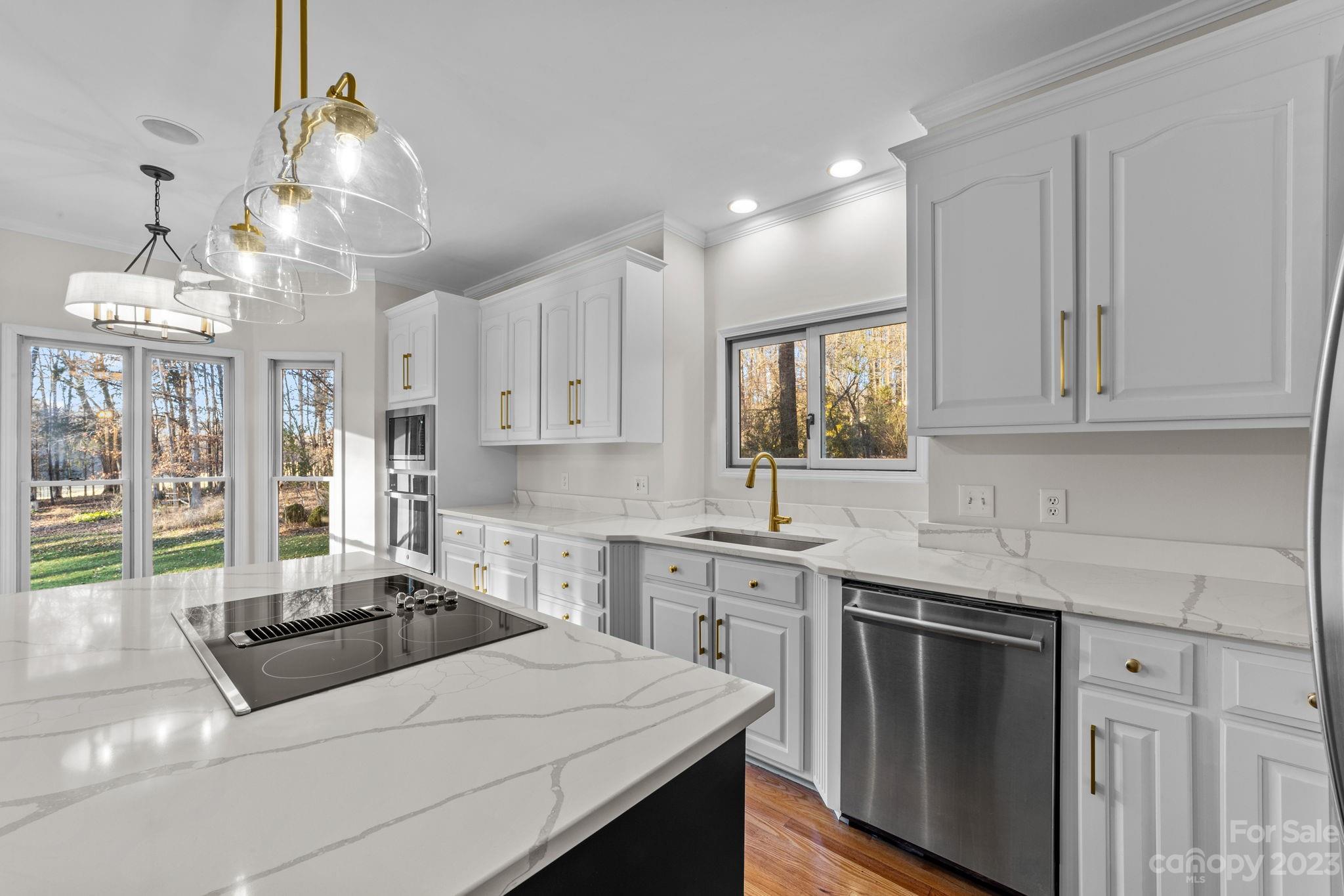 5476 Deer Run Court Davidson, NC 28036 - Photo 25 of 48 a kitchen with stainless steel appliances granite countertop a sink stove and white cabinets with wooden floor