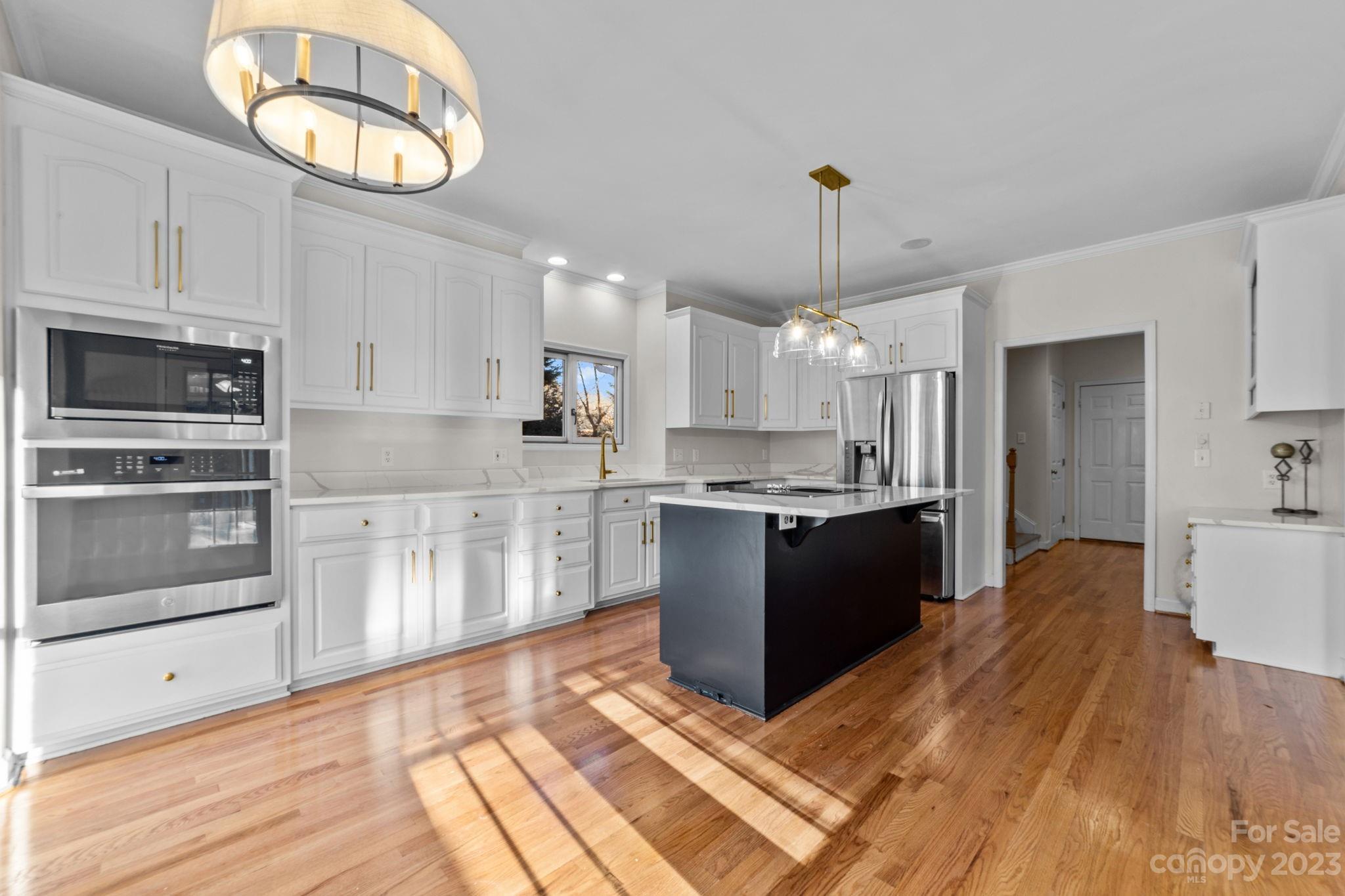 5476 Deer Run Court Davidson, NC 28036 - Photo 27 of 48 a kitchen with stainless steel appliances kitchen island granite countertop a stove a sink and a microwave
