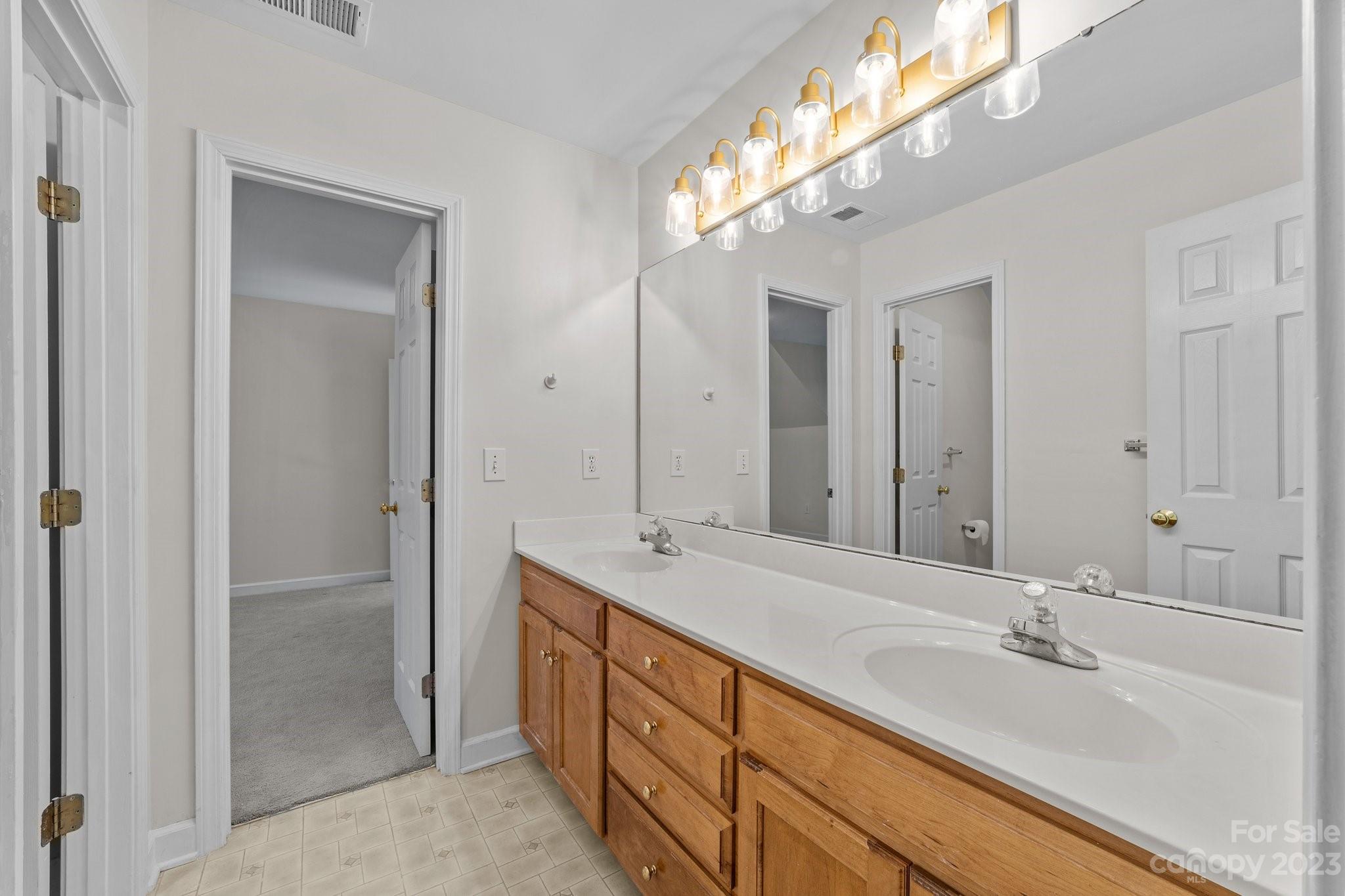 5476 Deer Run Court Davidson, NC 28036 - Photo 40 of 48 a spacious bathroom with a double vanity sink and a mirror
