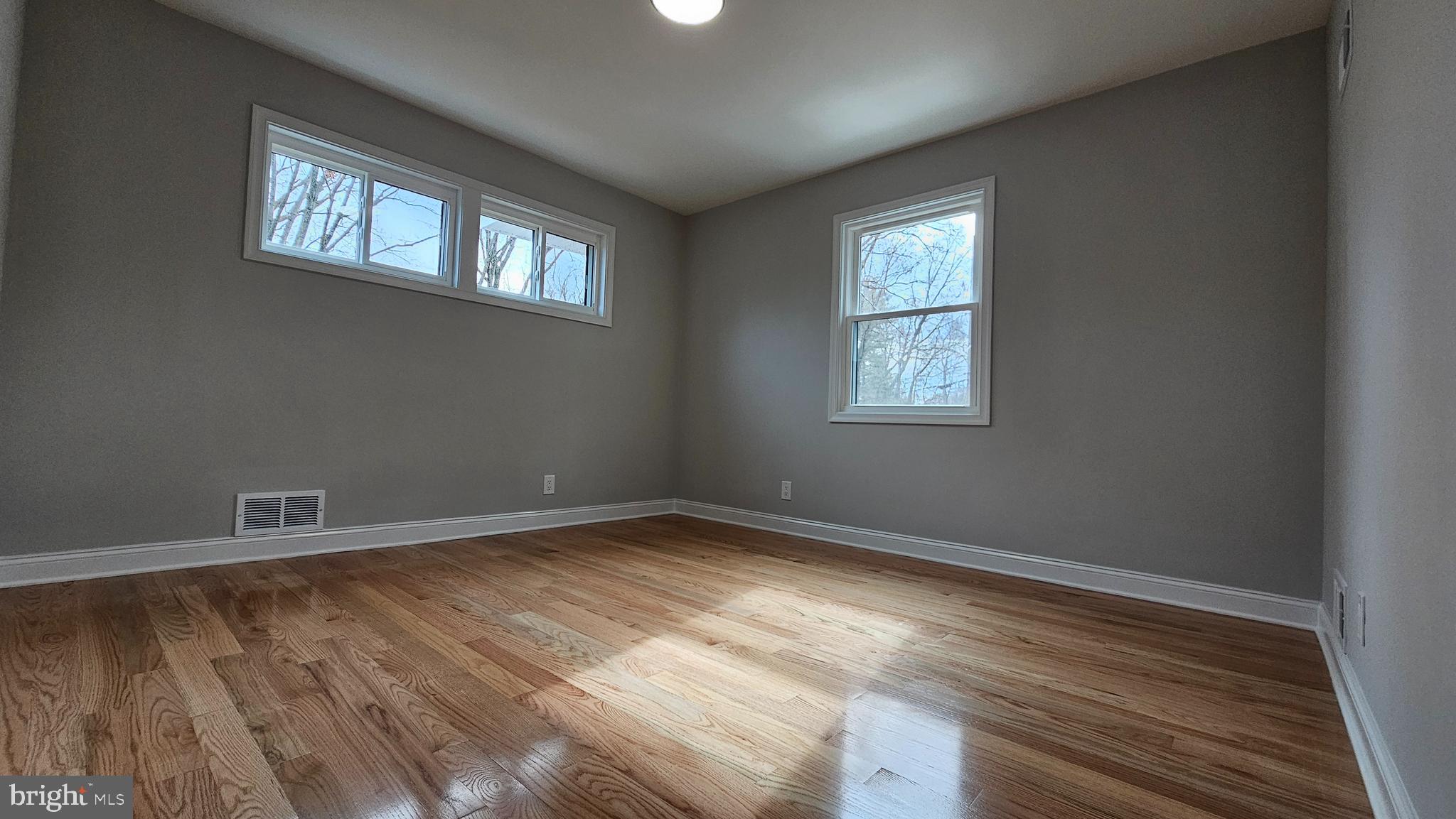 1305 Woodside Parkway Silver Spring, MD 20910 - Photo 21 of 41 an empty room with wooden floor and windows
