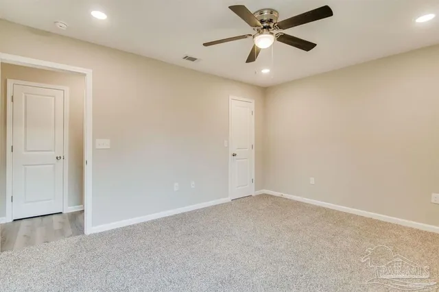 a view of empty room with a ceiling fan and window