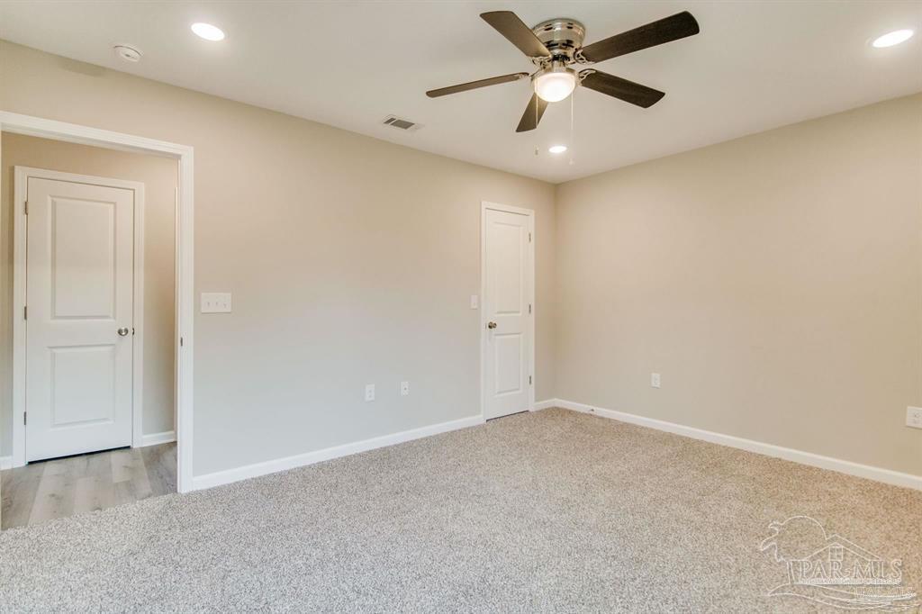 5601 Riviera Drive Milton, FL 32583 - Photo 12 of 18 an empty room with a ceiling fan and a ceiling fan