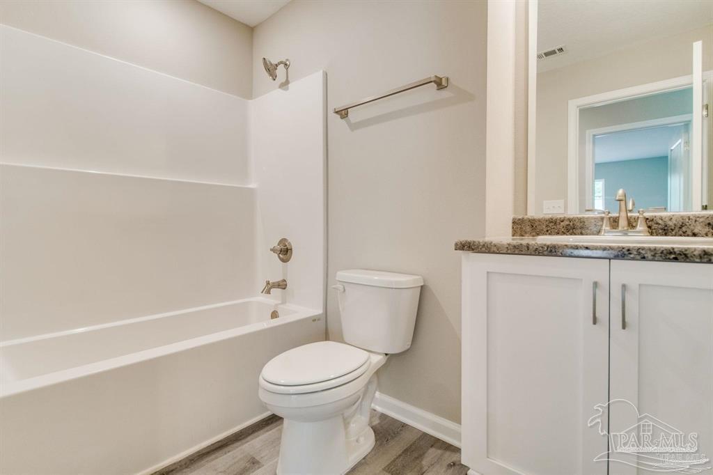 5601 Riviera Drive Milton, FL 32583 - Photo 15 of 18 a bathroom with a granite countertop sink toilet and shower