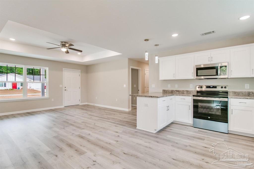 5601 Riviera Drive Milton, FL 32583 - Photo 5 of 18 a kitchen with stainless steel appliances a stove a sink and a refrigerator