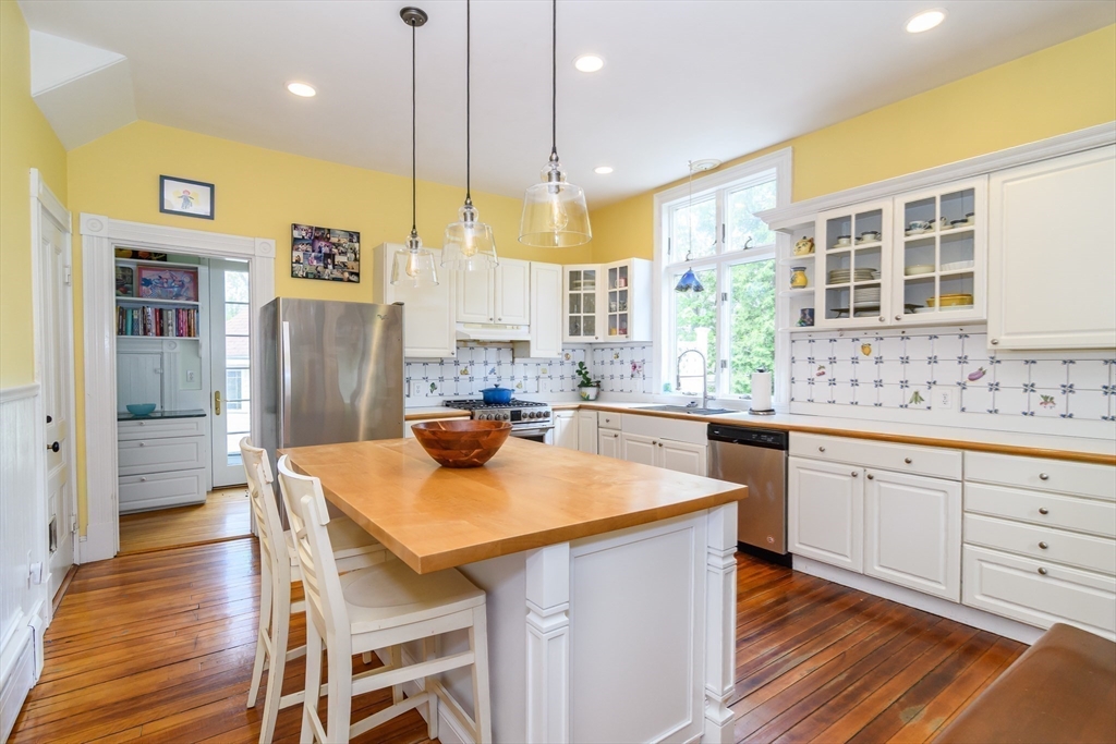 8 Charles Street Natick, MA 01760 - Photo 14 of 36 a kitchen with stainless steel appliances granite countertop a table chairs sink refrigerator and cabinets