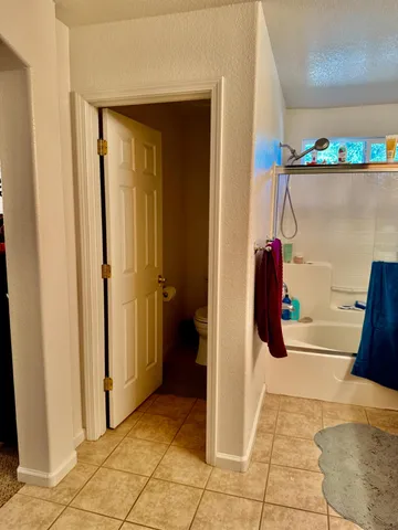 a bed sitting in a bedroom next to a lamp