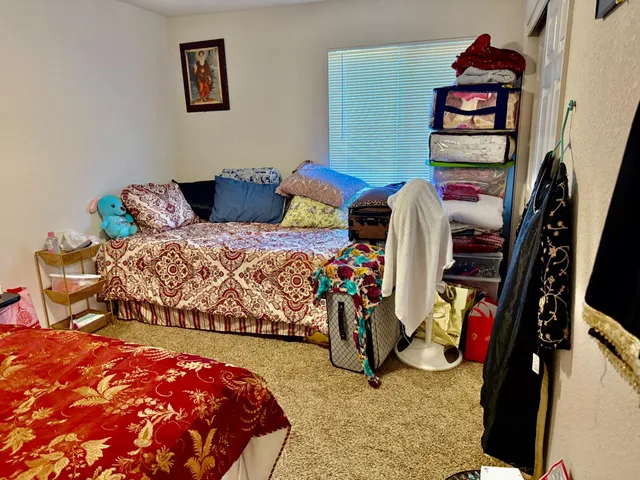 a bedroom with two bed and a painting on the wall