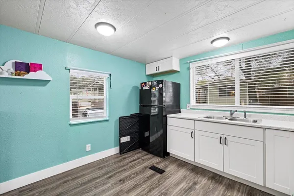 a kitchen with a refrigerator and white cabinets