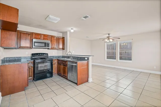 a kitchen with stainless steel appliances granite countertop a stove a sink and a microwave