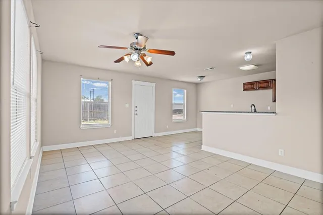 a view of a livingroom with a chandelier fan and windows