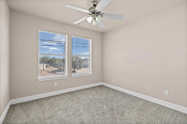 an empty room with a window and a fan