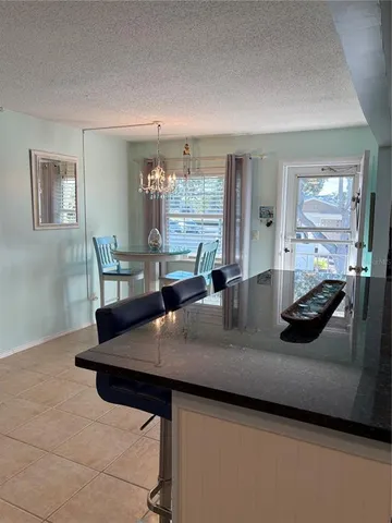 a view of kitchen island a sink wooden floor dining table and chairs