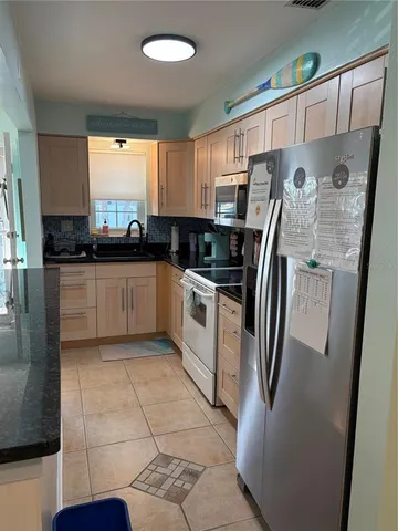a kitchen with stainless steel appliances a refrigerator sink and microwave
