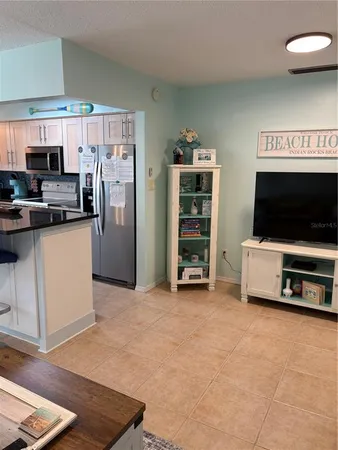 a view of kitchen with furniture and electronic appliances