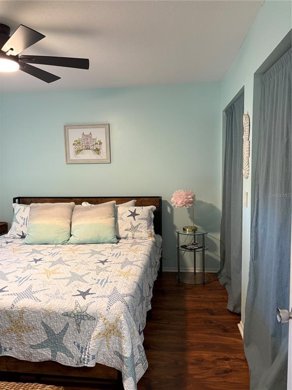 14531 Walsingham Road, Unit 224 Largo, FL 33774 - Photo 24 of 41 a bed sitting in a bedroom next to a window with a chandelier