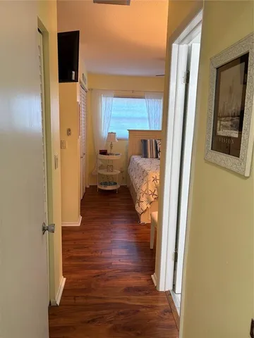 a view of a hallway with wooden floor windows and a livingroom