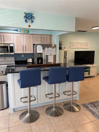 a kitchen with stainless steel appliances kitchen island granite countertop a table and chairs in it