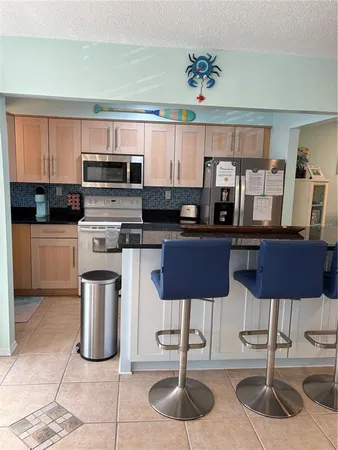 a kitchen with stainless steel appliances kitchen island granite countertop a sink and cabinets