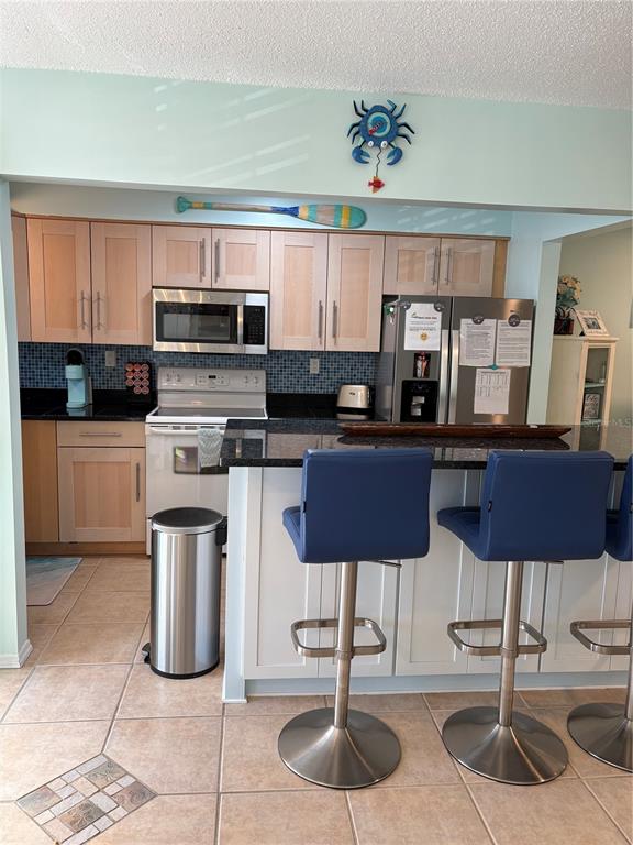 14531 Walsingham Road, Unit 224 Largo, FL 33774 - Photo 5 of 41 a kitchen with stainless steel appliances kitchen island granite countertop a sink and cabinets