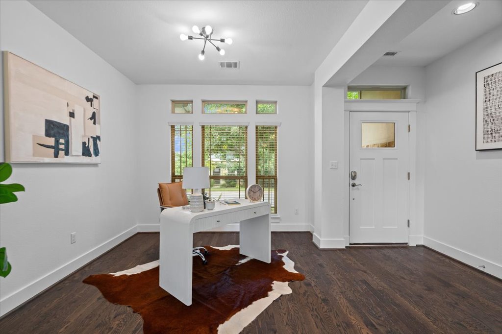 1765 Rowdy Loop, Unit 47 Leander, TX 78641 - Photo 8 of 40 Rich hardwood floors and classic crown molding elevate this versatile front-facing home workspace.