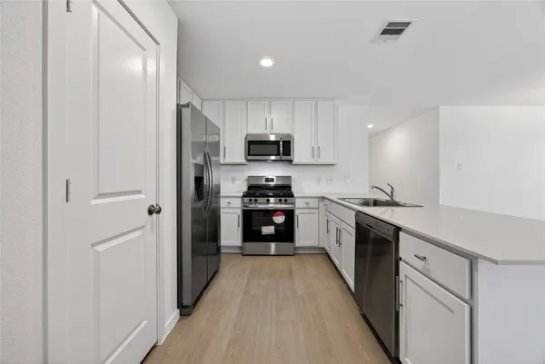 a kitchen with stainless steel appliances a refrigerator and a stove top oven