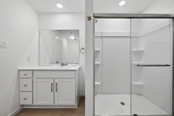 a bathroom with a shower sink and mirror