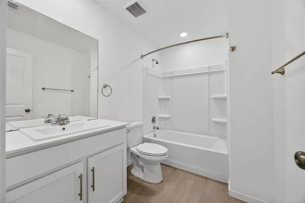 a bathroom with a double vanity sink toilet mirror and shower
