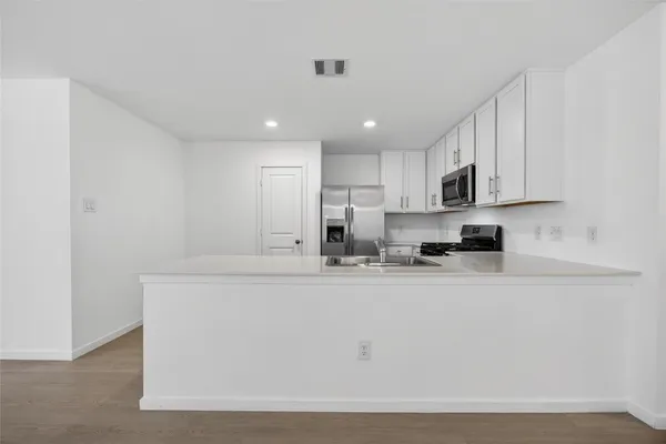 a kitchen with stainless steel appliances granite countertop a sink a stove and a refrigerator