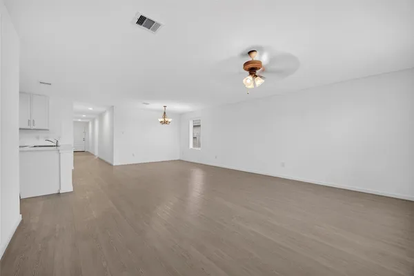wooden floor in an empty room with a kitchen
