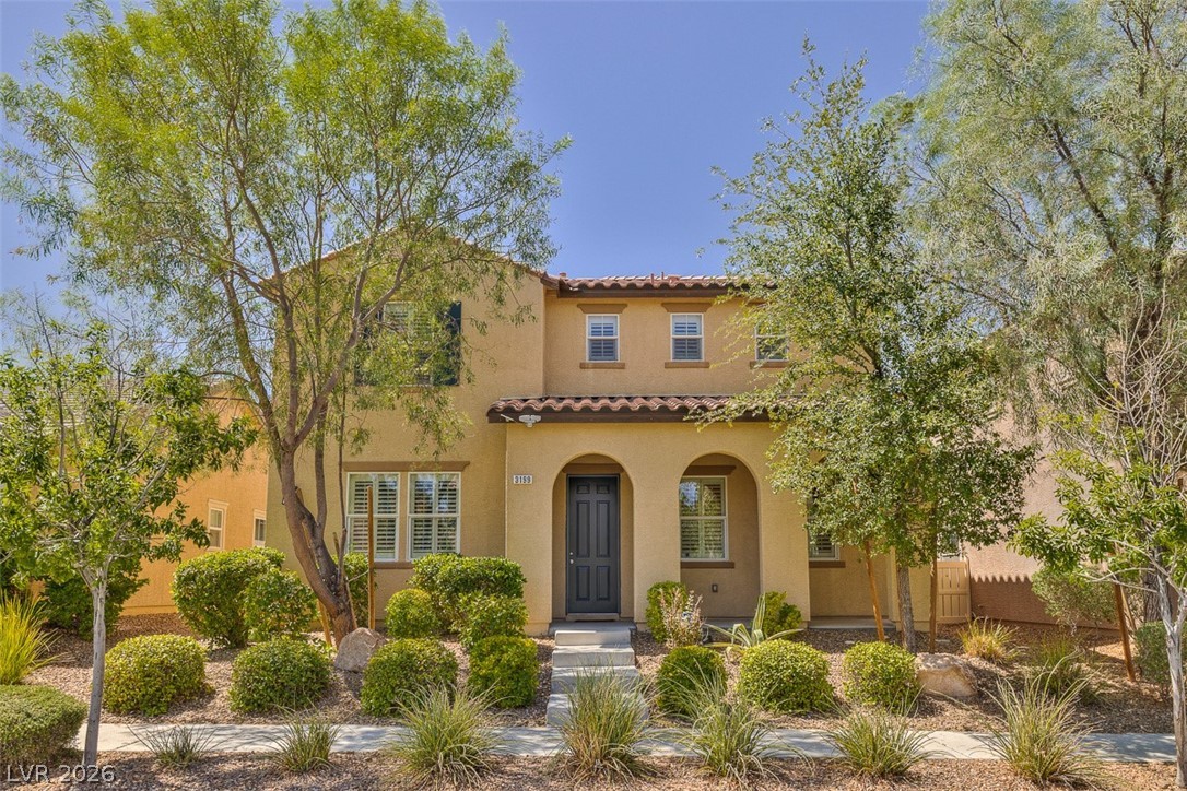 Mediterranean / spanish house with a porch, stucco siding, and a tile roof
