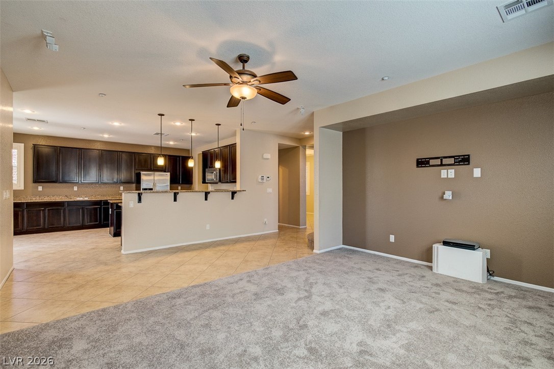 3199 Subtle Color Avenue Henderson, NV 89044 - Photo 11 of 46 Unfurnished living room featuring ceiling fan, light tile patterned flooring, light carpet, and recessed lighting