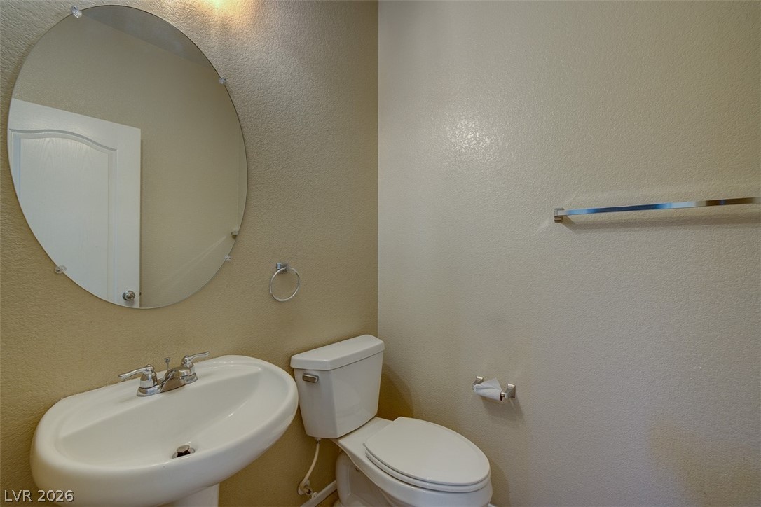 3199 Subtle Color Avenue Henderson, NV 89044 - Photo 20 of 46 Half bath featuring a textured wall and a sink