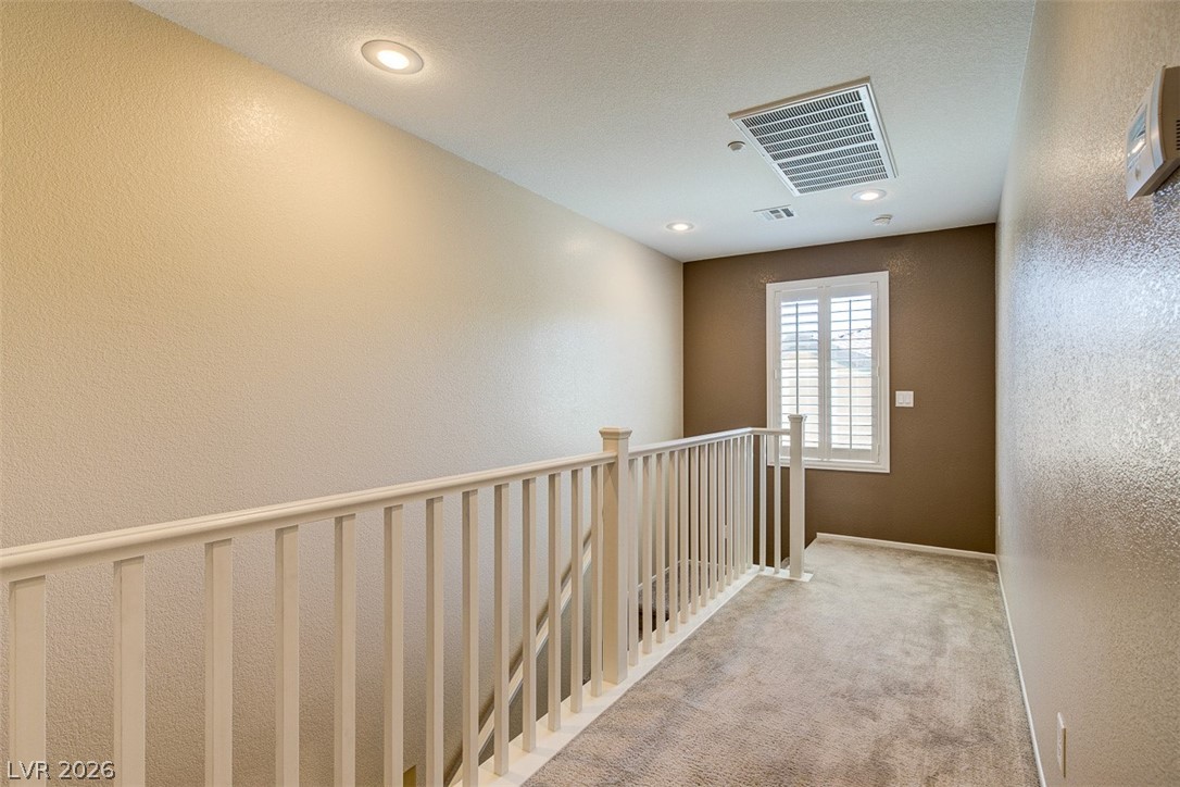 3199 Subtle Color Avenue Henderson, NV 89044 - Photo 21 of 46 Hallway with a textured wall, carpet, and recessed lighting