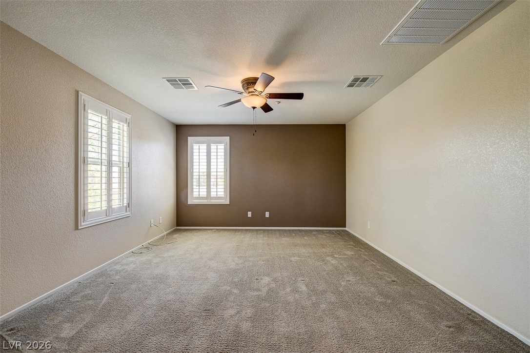 3199 Subtle Color Avenue Henderson, NV 89044 - Photo 23 of 46 Carpeted empty room with a textured wall, a ceiling fan, and a textured ceiling