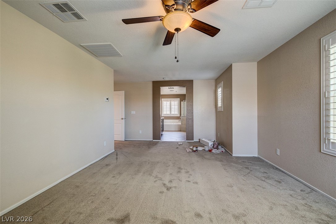 3199 Subtle Color Avenue Henderson, NV 89044 - Photo 24 of 46 Unfurnished room with ceiling fan, carpet, and a textured wall