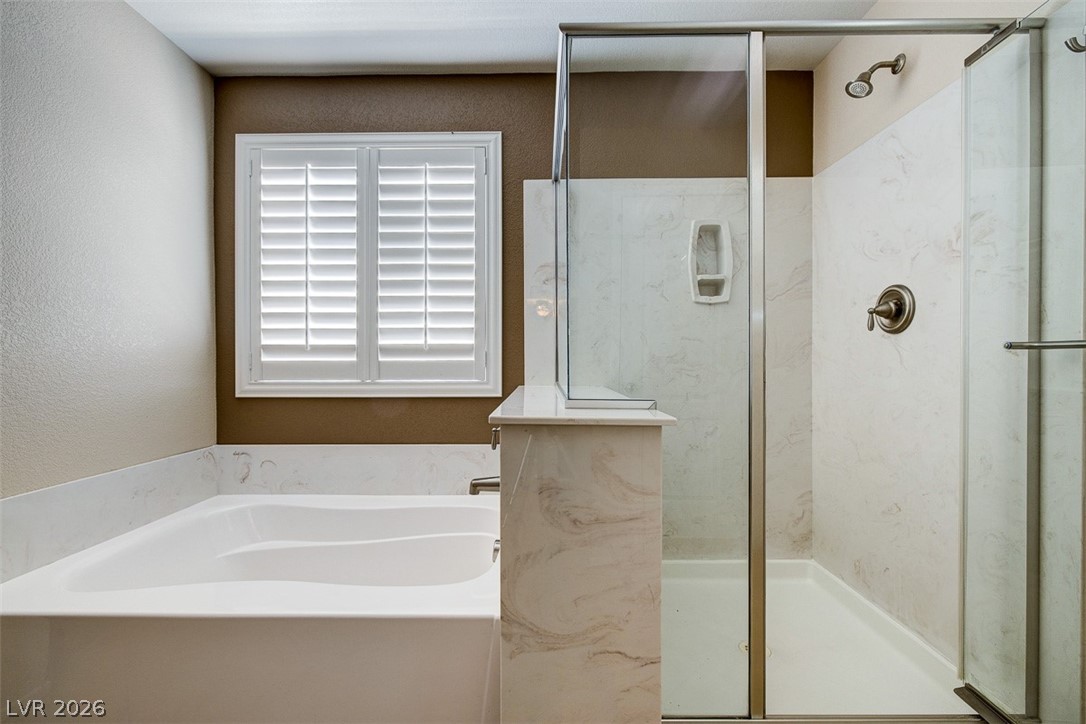 3199 Subtle Color Avenue Henderson, NV 89044 - Photo 26 of 46 Bathroom with a marble finish shower, a bath, and a textured wall