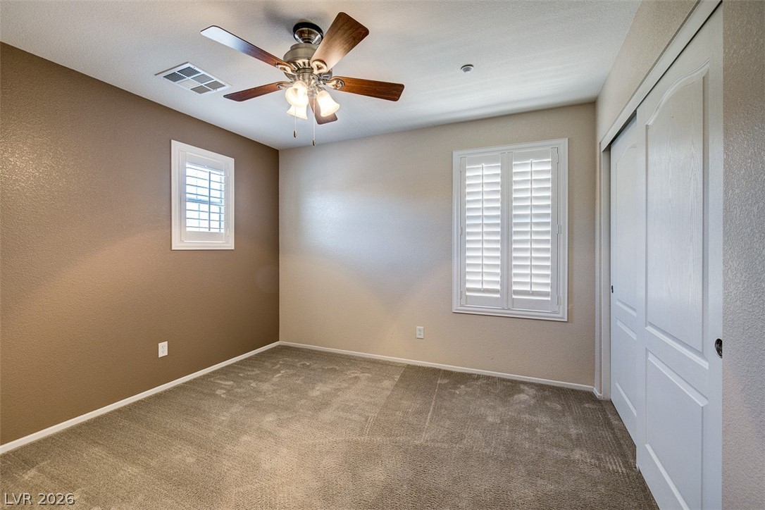3199 Subtle Color Avenue Henderson, NV 89044 - Photo 29 of 46 Unfurnished bedroom featuring carpet flooring, a closet, ceiling fan, and a textured wall