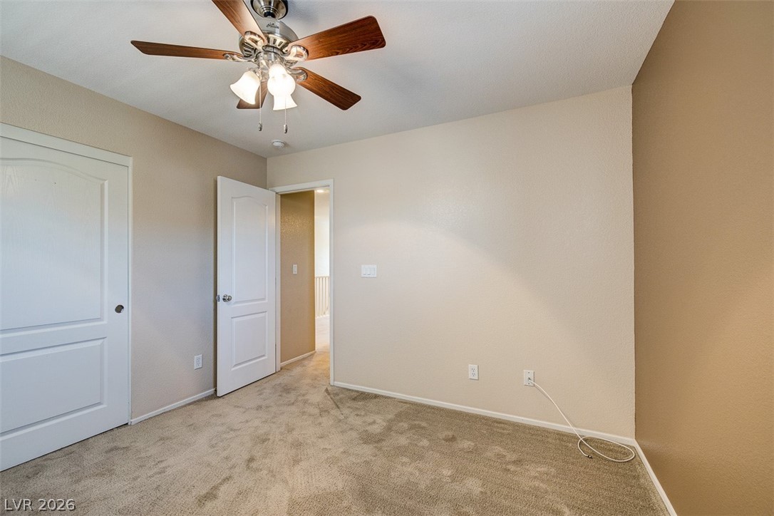 3199 Subtle Color Avenue Henderson, NV 89044 - Photo 30 of 46 Unfurnished bedroom featuring light carpet, a ceiling fan, and a closet