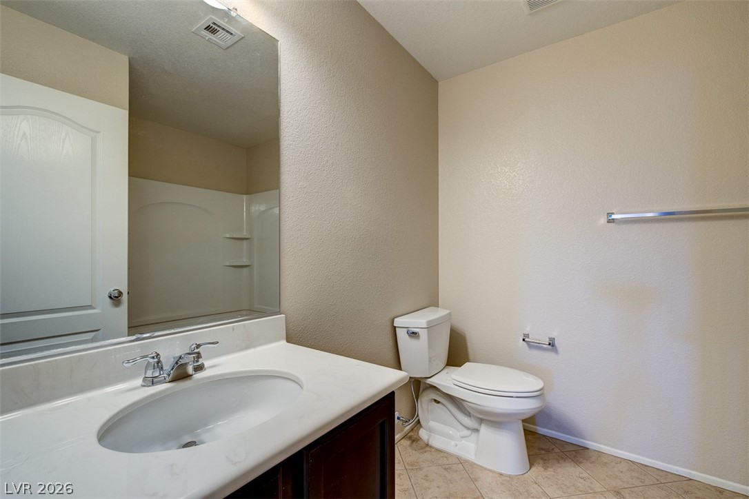 3199 Subtle Color Avenue Henderson, NV 89044 - Photo 31 of 46 Bathroom featuring vanity, a textured wall, and light tile patterned floors