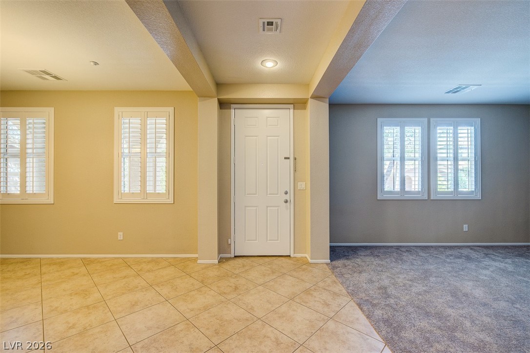 3199 Subtle Color Avenue Henderson, NV 89044 - Photo 5 of 46 Entrance foyer featuring light tile patterned floors, plenty of natural light, and light carpet