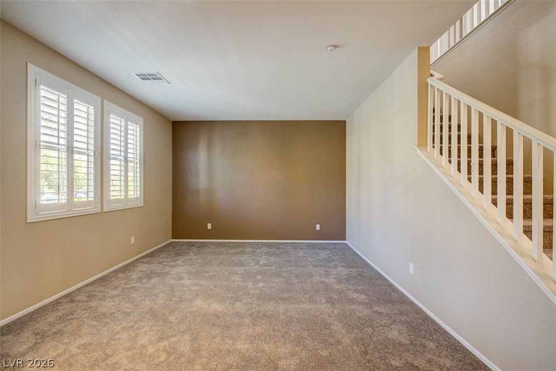 3199 Subtle Color Avenue Henderson, NV 89044 - Photo 7 of 46 Carpeted spare room with stairs and baseboards