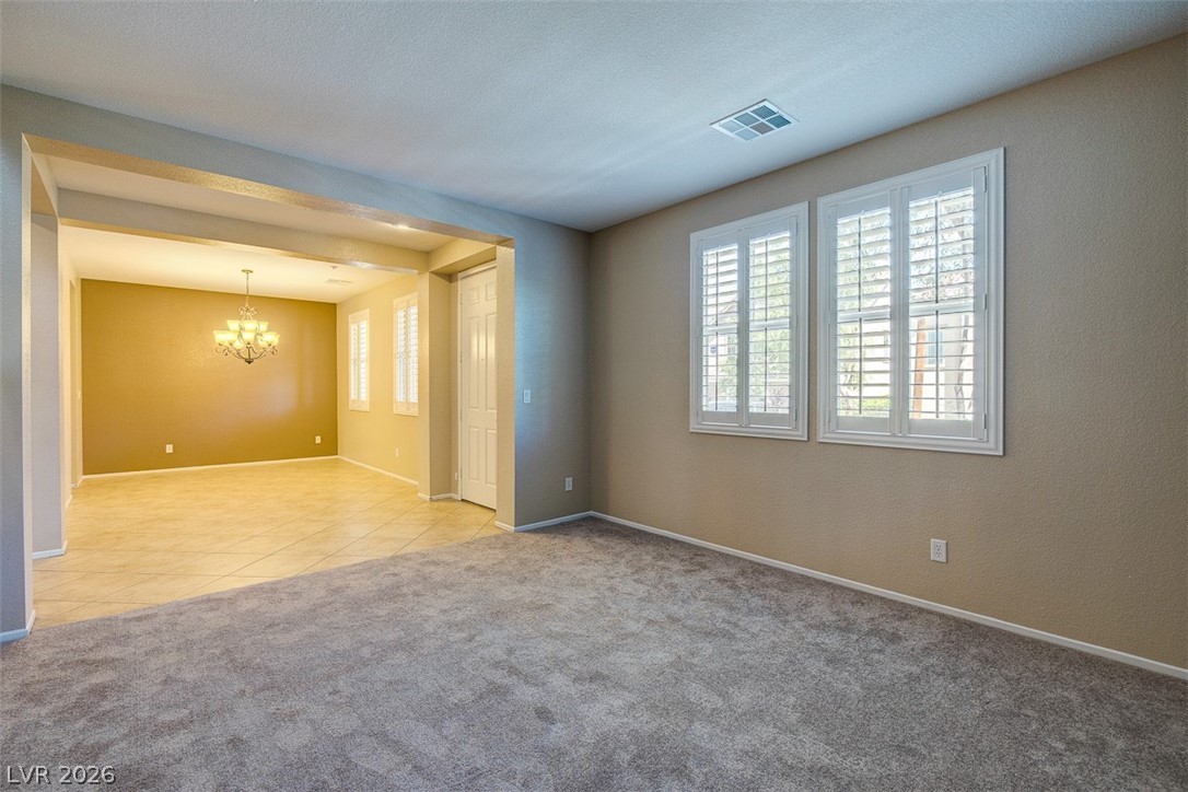 3199 Subtle Color Avenue Henderson, NV 89044 - Photo 8 of 46 Spare room with light colored carpet and suspended lighting