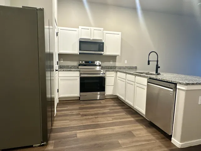 a kitchen with stainless steel appliances a sink stove and microwave