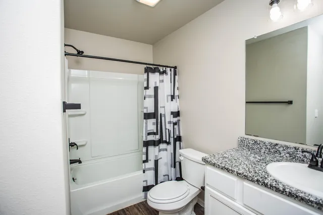 a bathroom with a granite countertop toilet sink and shower