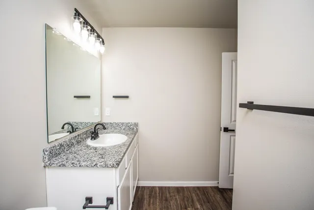a bathroom with a granite countertop sink and a mirror