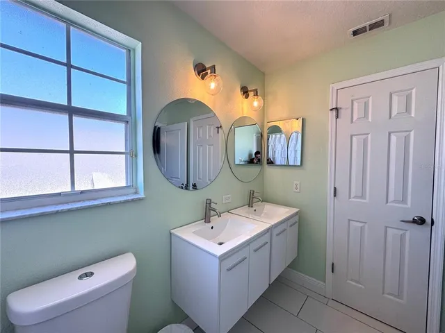 a bathroom with a toilet sink and mirror