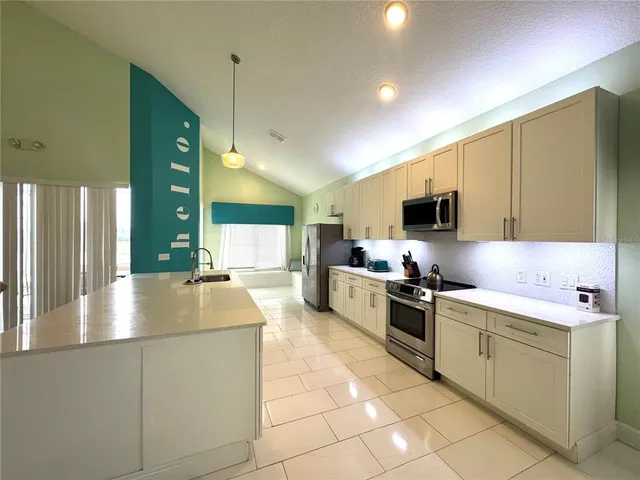 a kitchen with stainless steel appliances granite countertop a sink and a stove