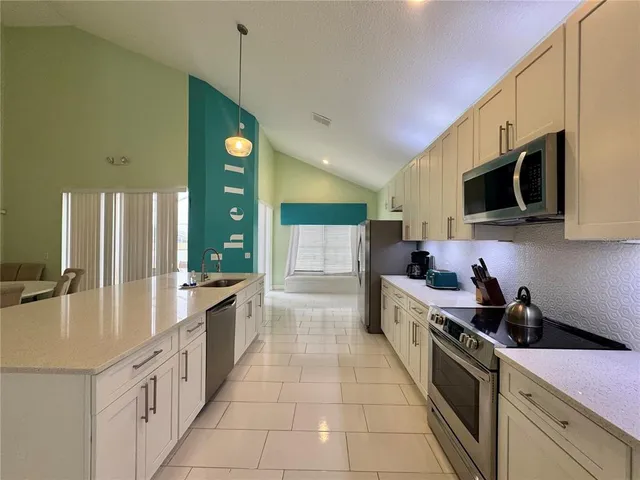 a large kitchen with stainless steel appliances granite countertop a lot of counter space and wooden floors